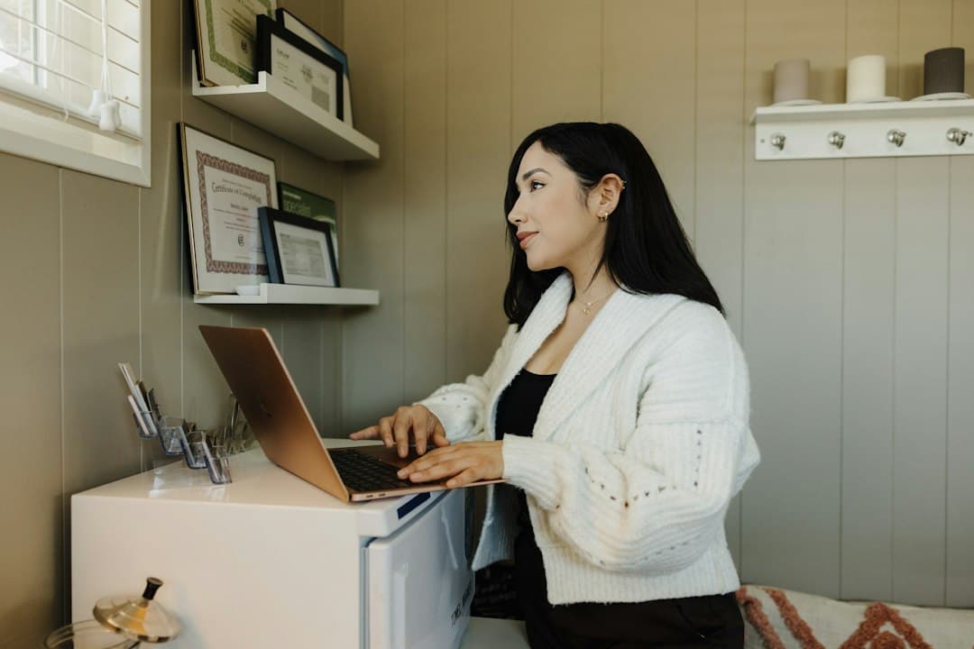 Small business owner working on a laptop in a home office, planning a Zyminex IPTV reseller business